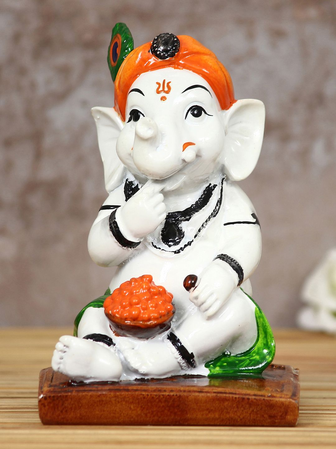 eCraftIndia White & Orange-Colored Lord Ganesha Eating Ladoo In Lord Krishna Avatar Decorative Showpiece Price in India