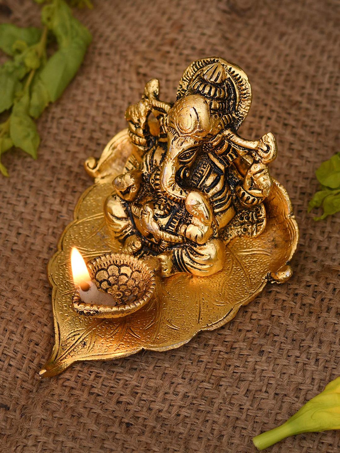CraftVatika Gold-Toned & Black Ganesha On Leaf With Diya Showpiece Price in India