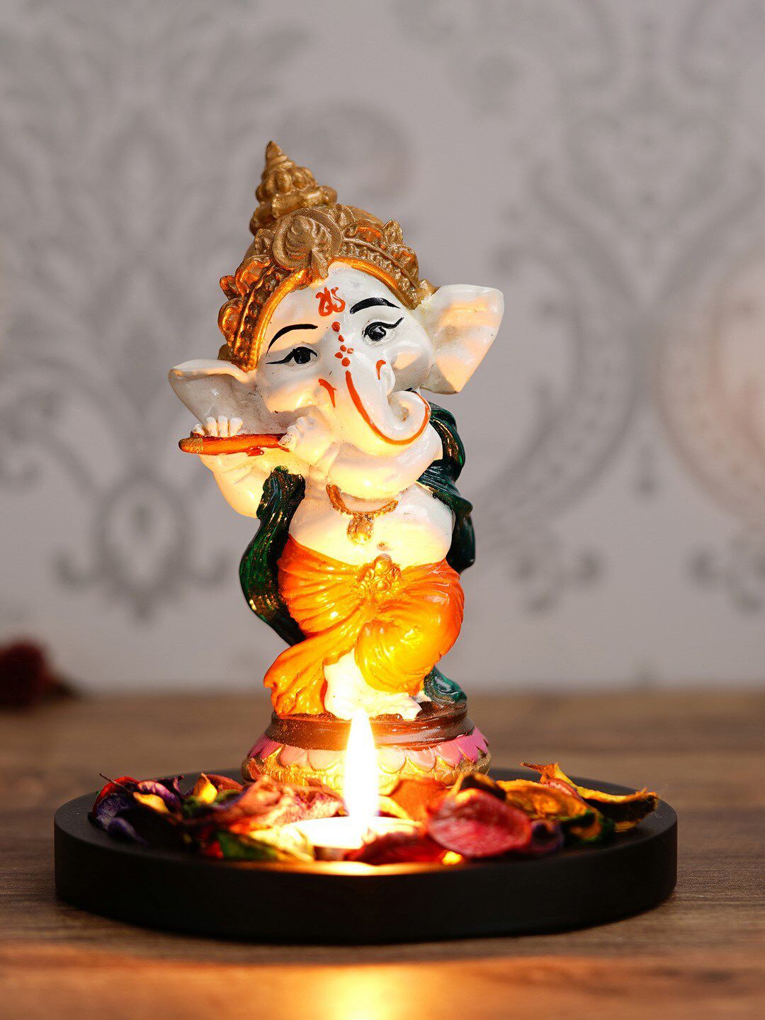 eCraftIndia Orange & White Lord Ganesha Dancing Avatar With Wooden Base Petals & Tealight Price in India