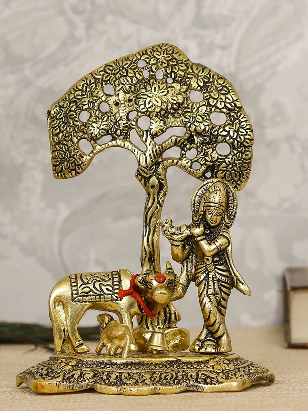 TIED RIBBONS Gold-Toned Krishna Playing Flute With Kamdhenu Cow Standing Under Tree Idol Showpiece Price in India