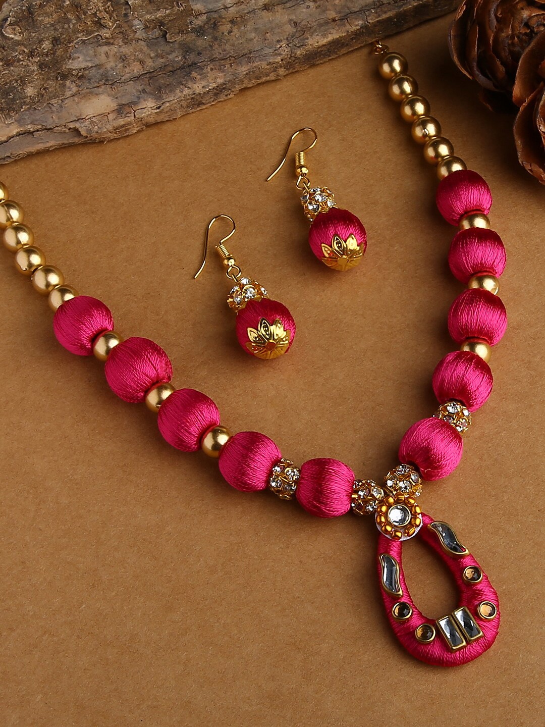 AKSHARA Gold-Plated White Stone-Studded Pink Wooden Balls Silk Thread Jewellery Set
AKSHARA Gold-Plated White Stone-Studded Pink Wooden Balls Silk Thread Jewellery Set