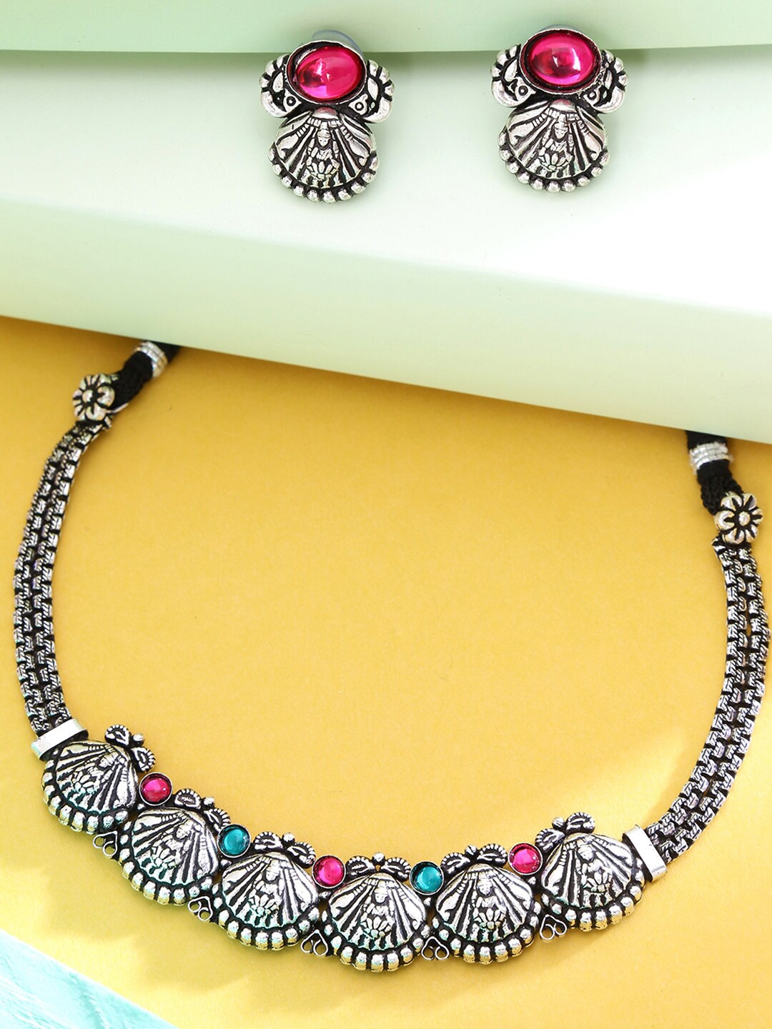Yellow Chimes Oxidised Silver-Plated Pink & Blue Stone-Studded Kolhapuri Jewellery Set
Yellow Chimes Oxidised Silver-Plated Pink & Blue Stone-Studded Kolhapuri Jewellery Set