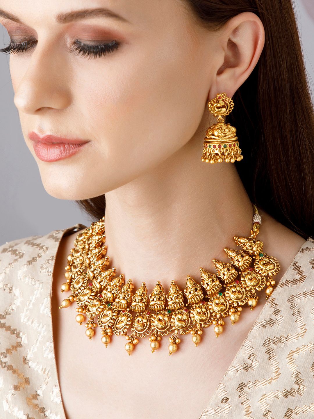 Rubans 24K Gold Plated Laxmi Motif Red Green Stone Studded Gold Beaded Temple Necklace Set
Rubans 24K Gold Plated Laxmi Motif Red Green Stone Studded Gold Beaded Temple Necklace Set