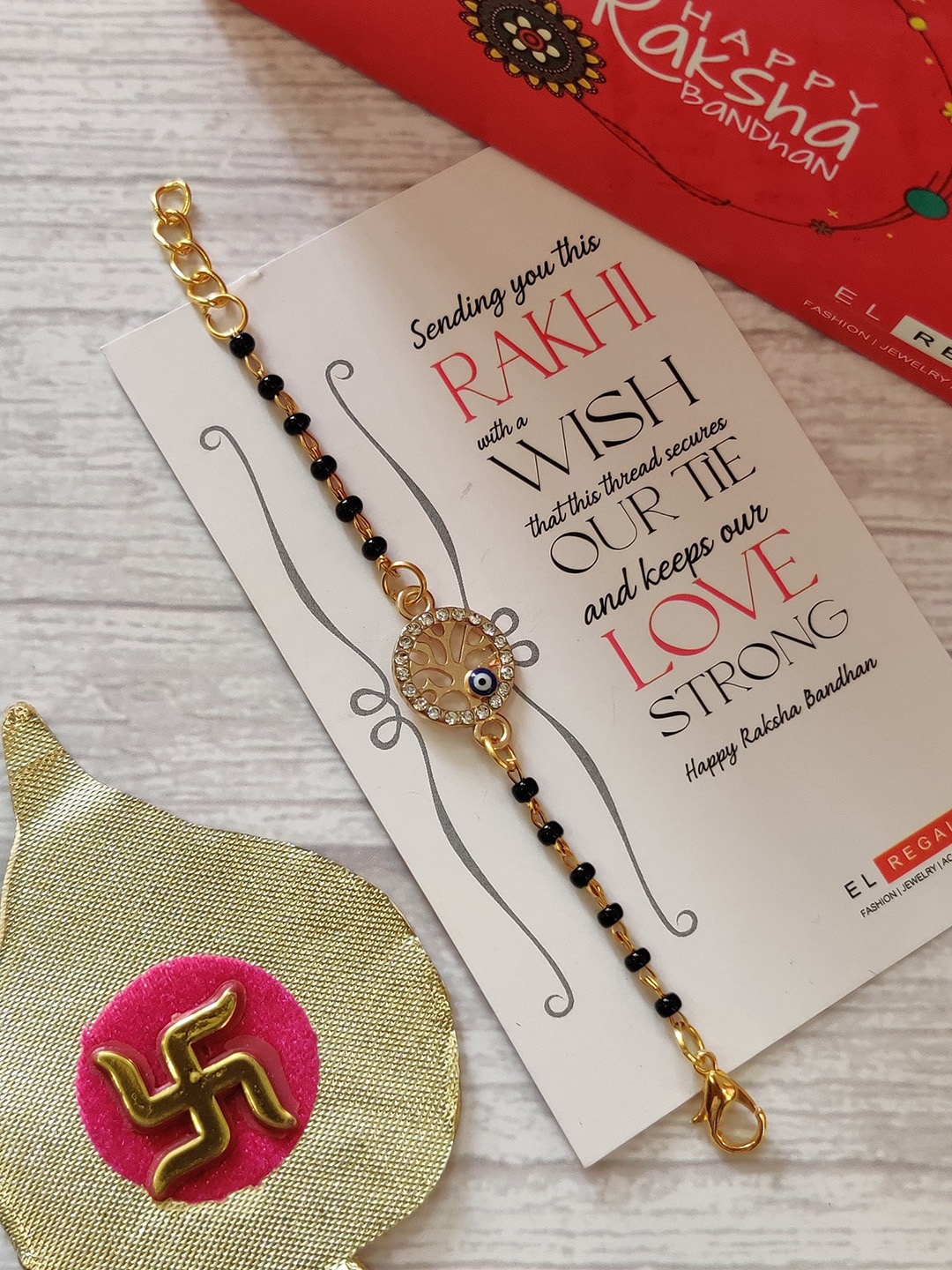 EL REGALO Kids Gold-Toned Nazaria Rakhi Combo with Greeting Card & Roli Chawal Shagun
EL REGALO Kids Gold-Toned Nazaria Rakhi Combo with Greeting Card & Roli Chawal Shagun