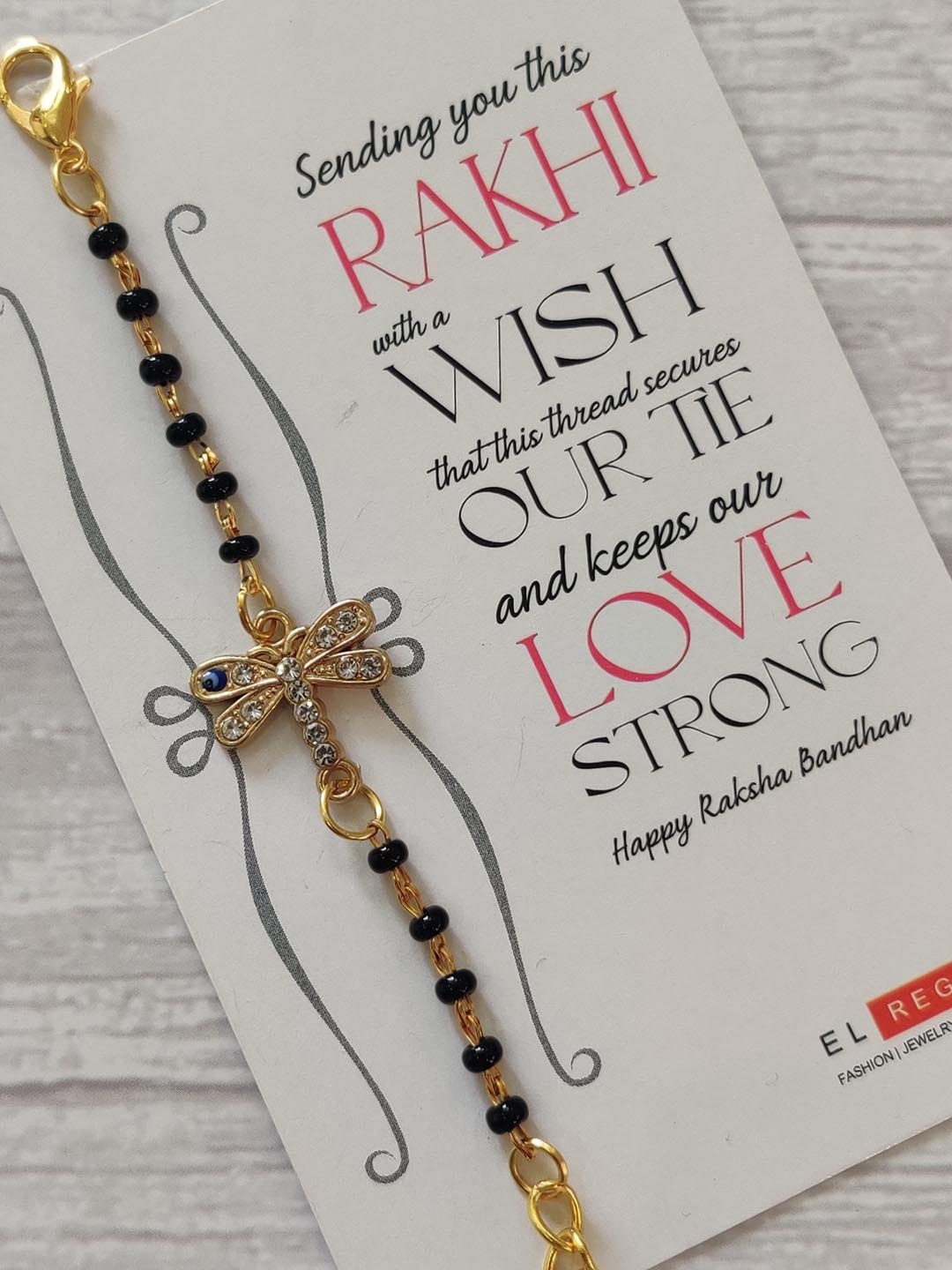 EL REGALO Kids Gold-Toned Nazaria Rakhi Combo with Greeting Card & Roli Chawal Shagun
EL REGALO Kids Gold-Toned Nazaria Rakhi Combo with Greeting Card & Roli Chawal Shagun