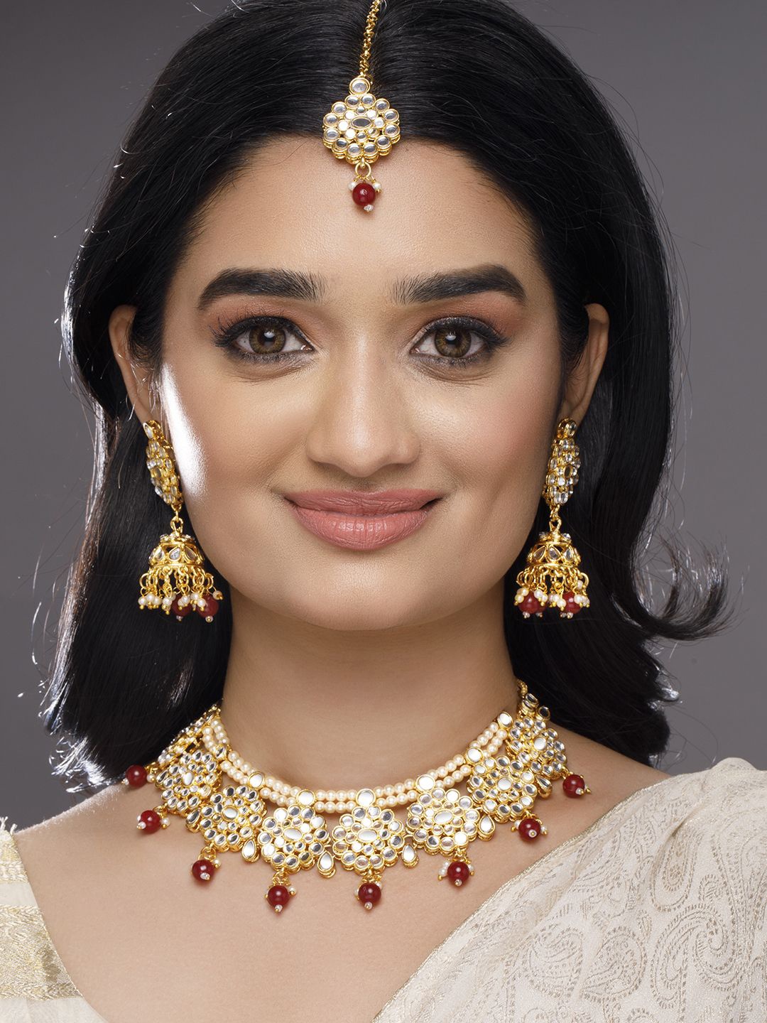 Rubans 22K Gold-Plated Kundan-Studded Choker Necklace Set with Red Beads and Pearl Accents
Rubans 22K Gold-Plated Kundan-Studded Choker Necklace Set with Red Beads and Pearl Accents