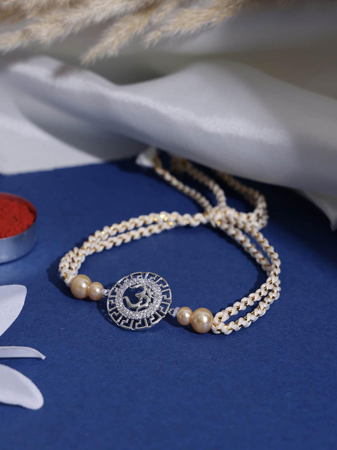 PANASH- 925 Sterling Silver -Plated Om Shaped CZ Stone Studded Rakhi With Roli Chawal
PANASH- 925 Sterling Silver -Plated Om Shaped CZ Stone Studded Rakhi With Roli Chawal