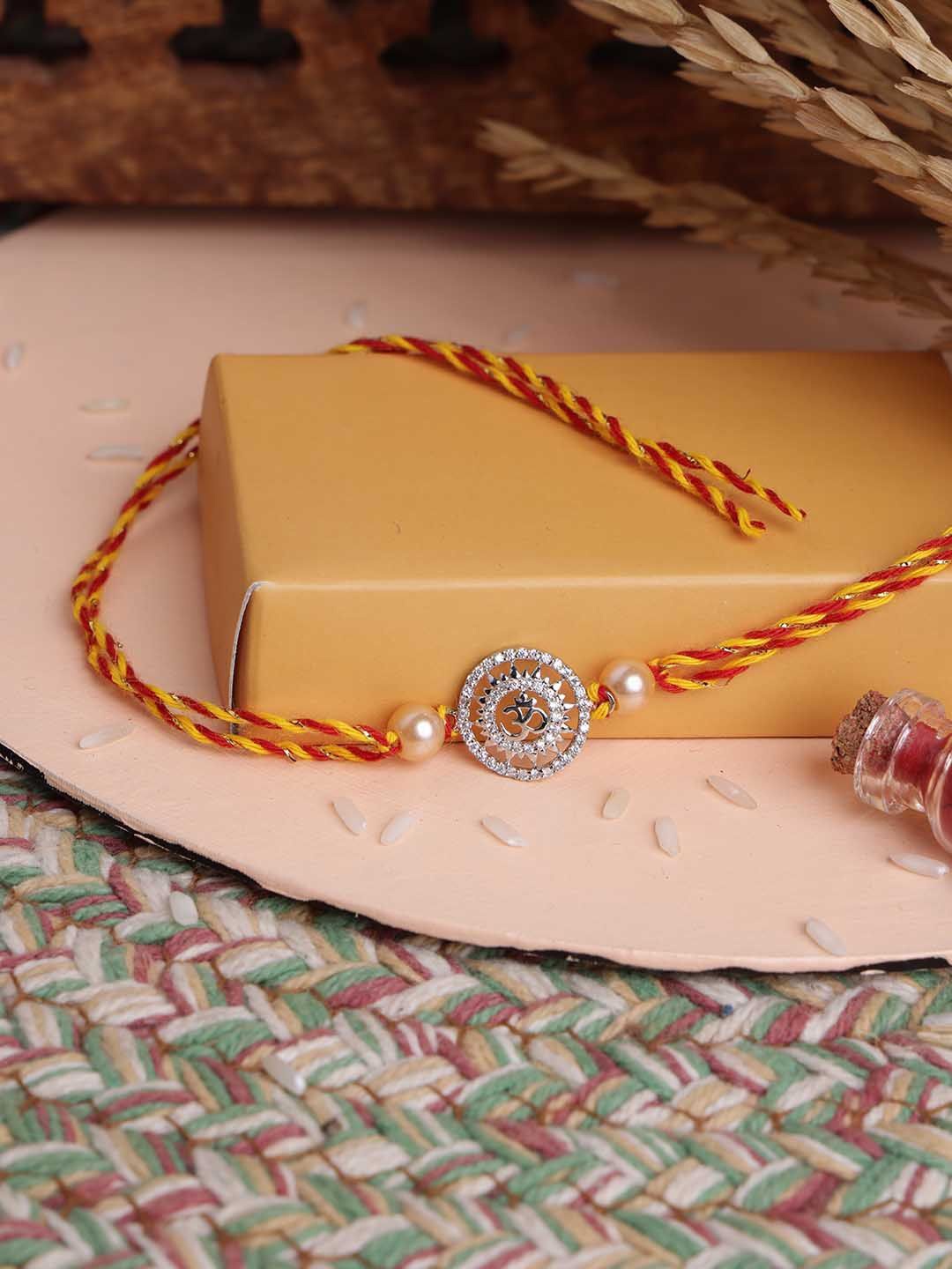PANASH- 925 Sterling Silver -Plated Om Shaped CZ Stone Studded Rakhi With Roli Chawal, Red
PANASH- 925 Sterling Silver -Plated Om Shaped CZ Stone Studded Rakhi With Roli Chawal, Red