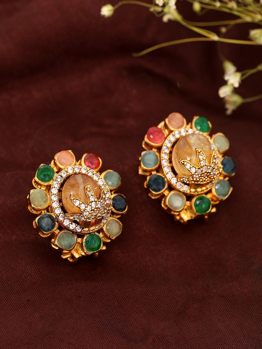 Exotic India Gold-Plated Artificial Stone Studded Floral Design Studs Earrings
Exotic India Gold-Plated Artificial Stone Studded Floral Design Studs Earrings