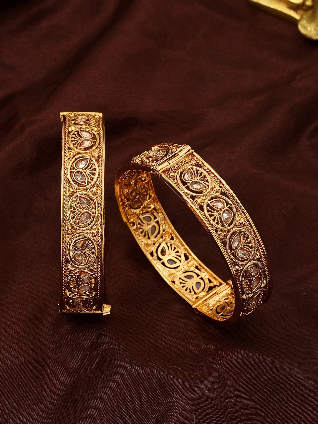 Exotic India Set Of 2 Gold-Plated Artificial Stone Studded Openable Bangles In Copper
Exotic India Set Of 2 Gold-Plated Artificial Stone Studded Openable Bangles In Copper