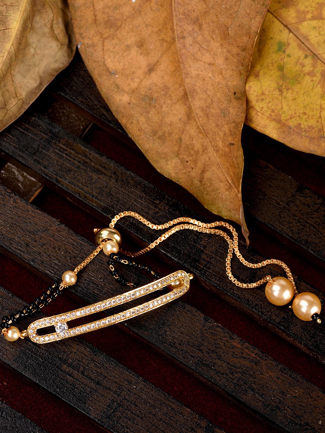 Saraf RS Jewellery Women Gold-Toned & Black Brass American Diamond Gold-Plated Charm Bracelet
Saraf RS Jewellery Women Gold-Toned & Black Brass American Diamond Gold-Plated Charm Bracelet