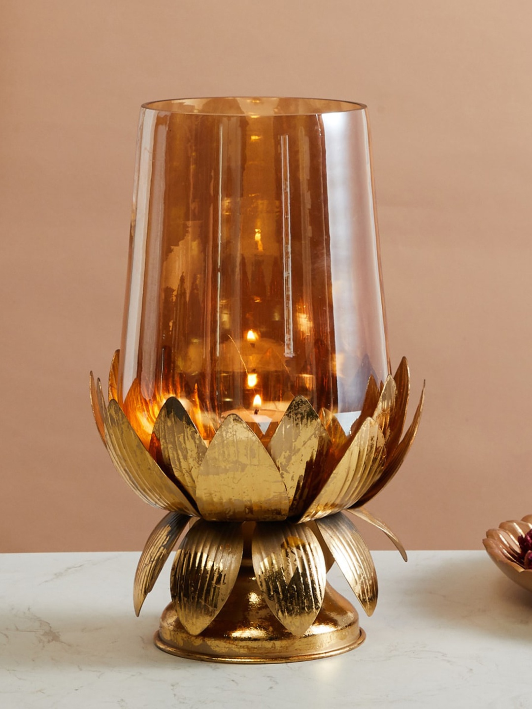 Home Centre Rylee Gold Toned Glass Hurricane With Lotus Metal Stand T-Light Candle Holder
Home Centre Rylee Gold Toned Glass Hurricane With Lotus Metal Stand T-Light Candle Holder