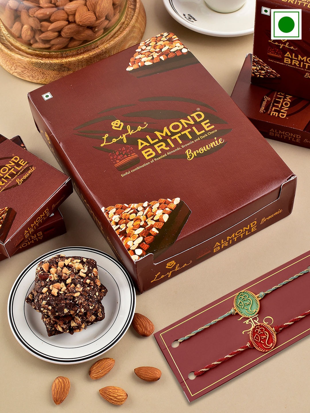 Hyperfoods Set Of 2 Ganesha Charm Rakhis With Loyka Almond Brownie Gift Set 240gm, Brown
Hyperfoods Set Of 2 Ganesha Charm Rakhis With Loyka Almond Brownie Gift Set 240gm, Brown