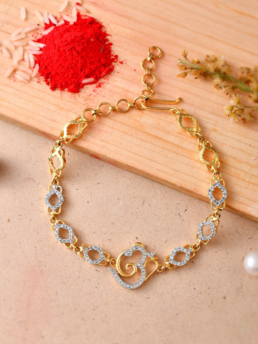 Aapno Rajasthan Unisex Gold-Plated Om Charm Americon Diamonds Studded Bracelet Rakhi
Aapno Rajasthan Unisex Gold-Plated Om Charm Americon Diamonds Studded Bracelet Rakhi