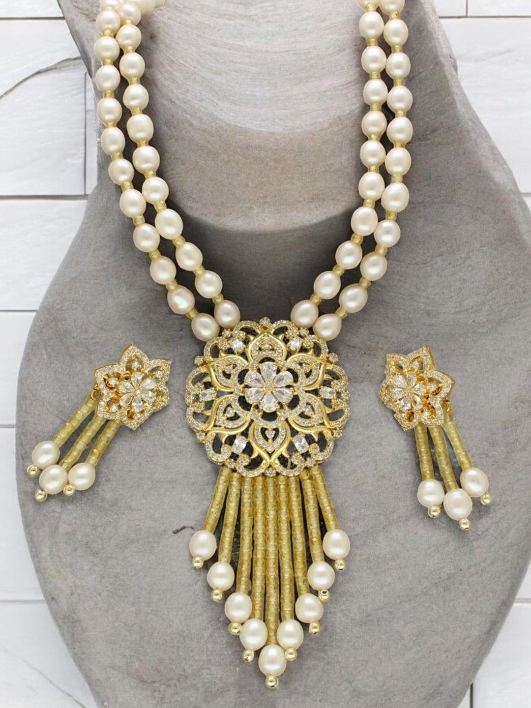 Sri Jagdamba Pearls Dealer Gold Plated CZ Stone Studded & Beaded Necklace and Earrings
Sri Jagdamba Pearls Dealer Gold Plated CZ Stone Studded & Beaded Necklace and Earrings