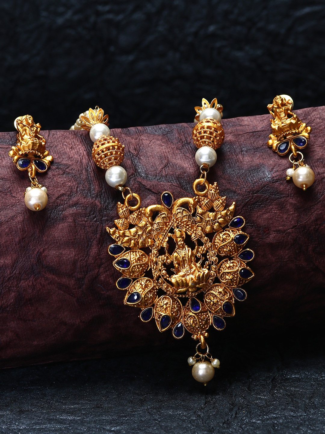 ANIKAS CREATION Gold-Plated & Navy Blue Stone-Studded Pearl Beaded Temple Jewellery Set
ANIKAS CREATION Gold-Plated & Navy Blue Stone-Studded Pearl Beaded Temple Jewellery Set
