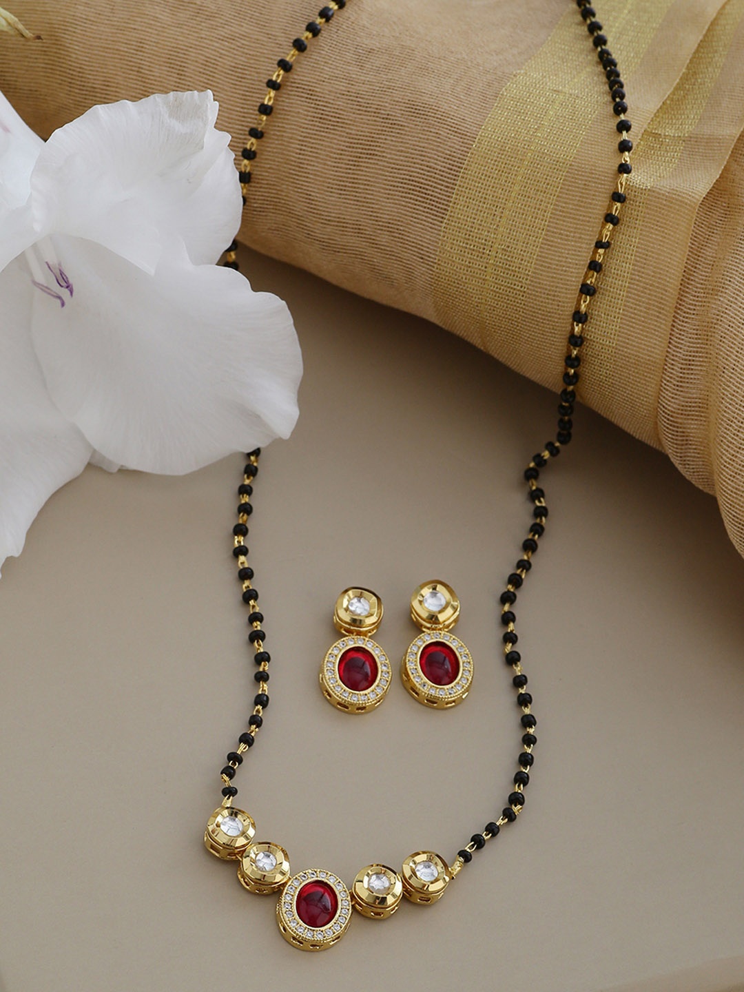 Shoshaa Gold-Toned & Black Beaded Kundan & Ruby Embellished Mangalsutra With Earrings
Shoshaa Gold-Toned & Black Beaded Kundan & Ruby Embellished Mangalsutra With Earrings
