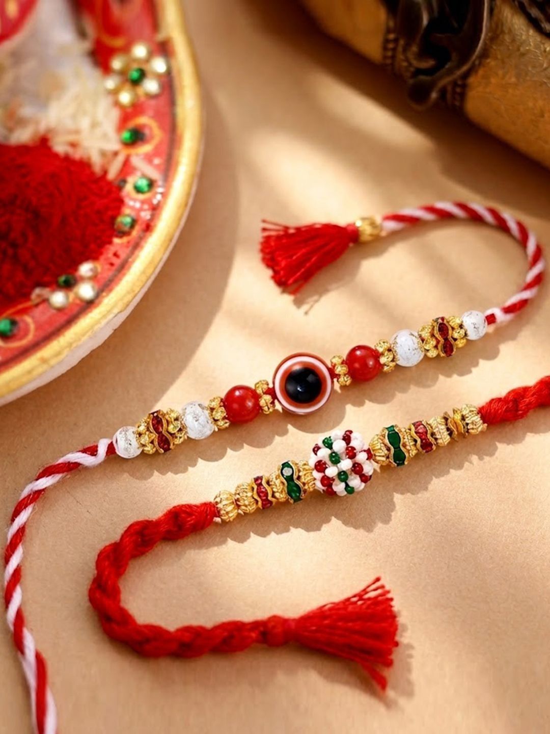 Peora Set Of 2 Gold-Toned Evil Eye & Meenakari Beaded Rakhi With Red Thread
