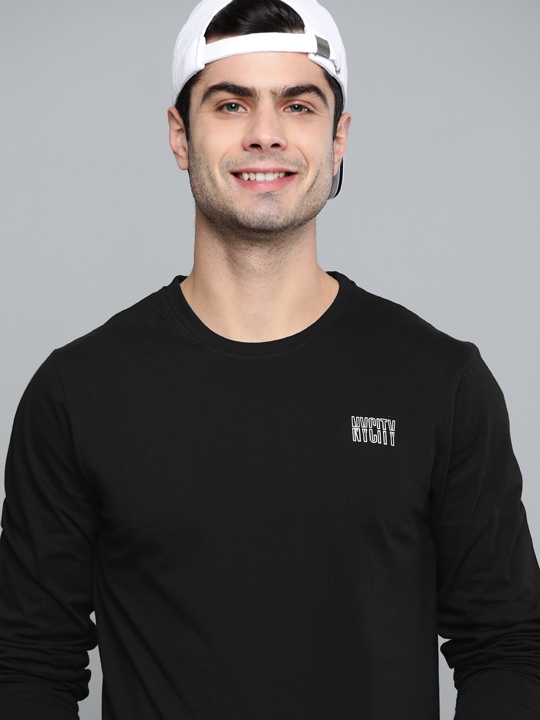 Man in black and white crew neck t-shirt wearing gray cap photo