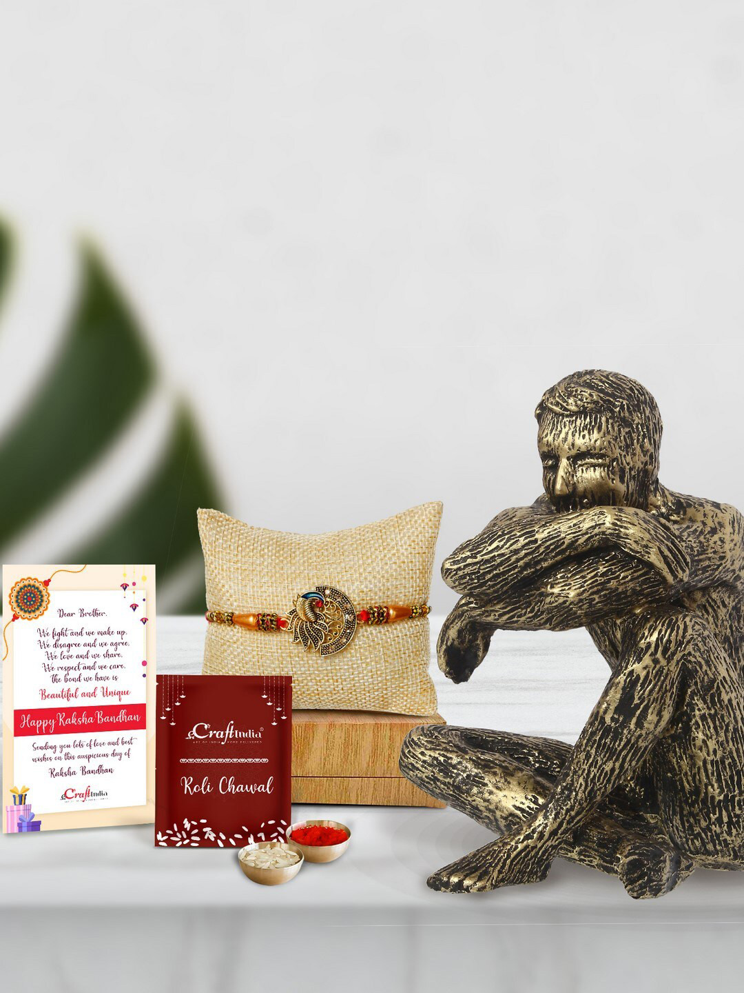 eCraftIndia Gold-Toned Man Sitting in Thinking Position Statue Peacock Rakhi Gift Set