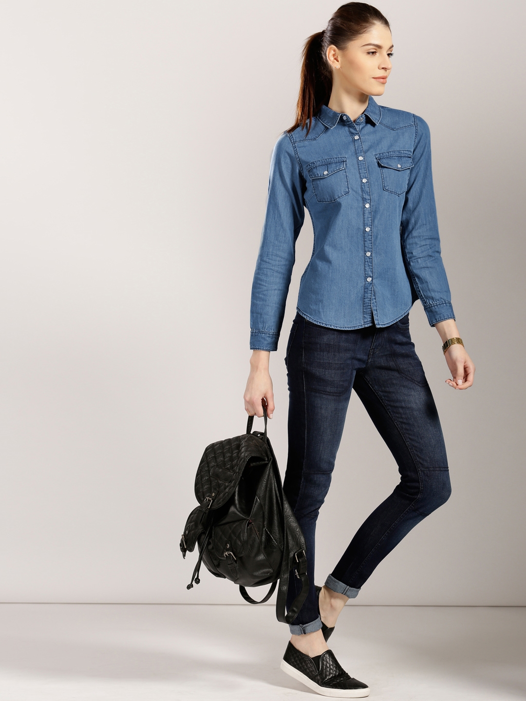 With denim shirt, blue bag and sneakers