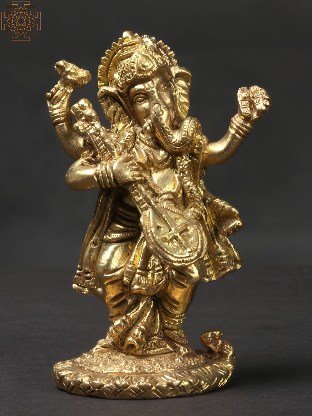 Exotic India Ganesha Playing Flute Against the Backdrop of a Tree Gold Brass Metallic Prayer Room Small Showpiece - 4.5 Inches