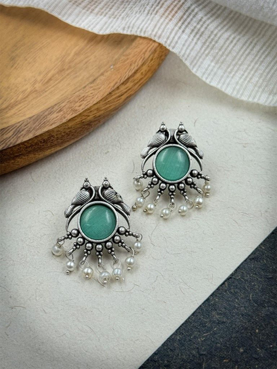 NAMAN ARTS Silver-Plated Stones Studded & Beaded Animal Shaped Oxidised Drop Earrings