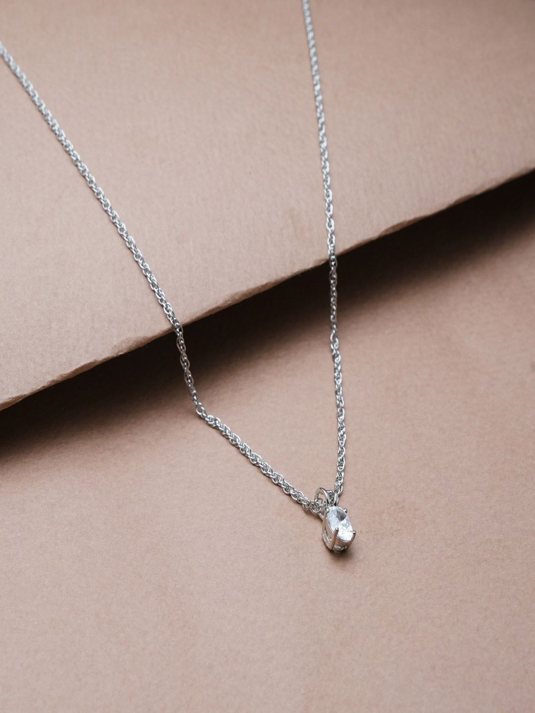 TASSYA Silver-Plated Solitaire Diamond Studded Oval Shaped Pendant With Chain