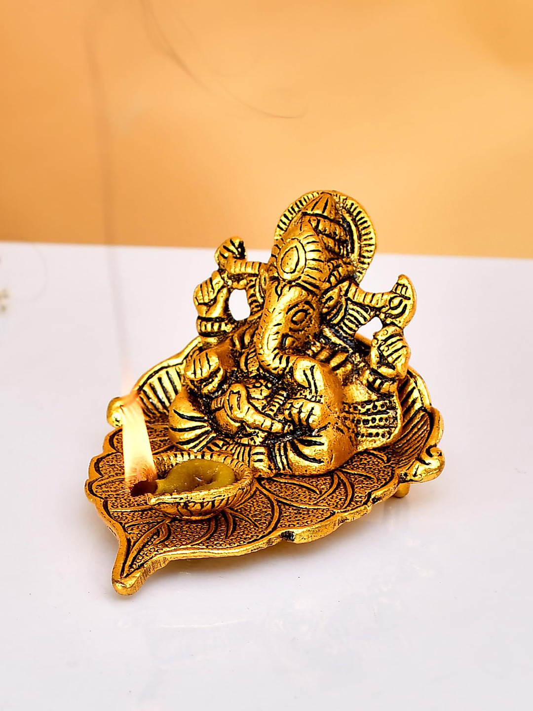 CRAFTAM Gold-Toned and Black Lord Ganesh on Leaf with Diya Metal Religious Idol Showpiece