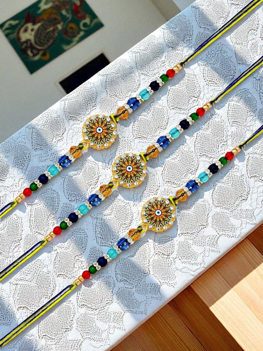 ADIVA Set Of 3 CZ Studded & Beaded Peacock Thread Rakhis With Roli Chawal