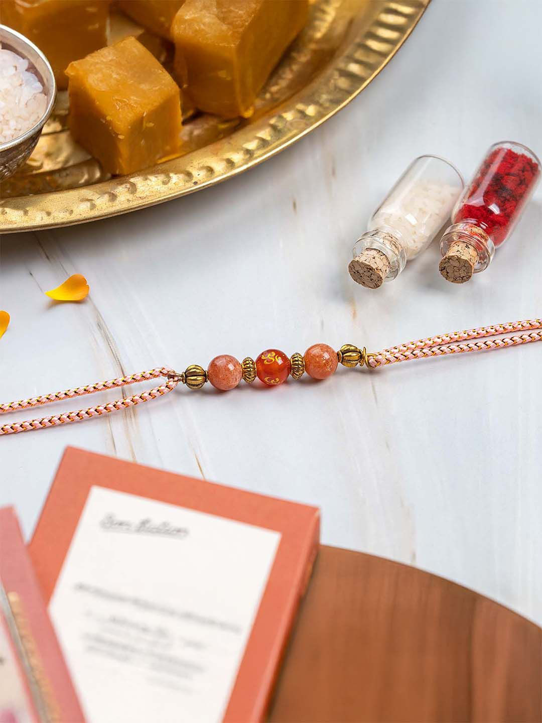Mesmerize Sunstone Red Om Natural Stone Thread Rakhi With Card & Roli Chawal