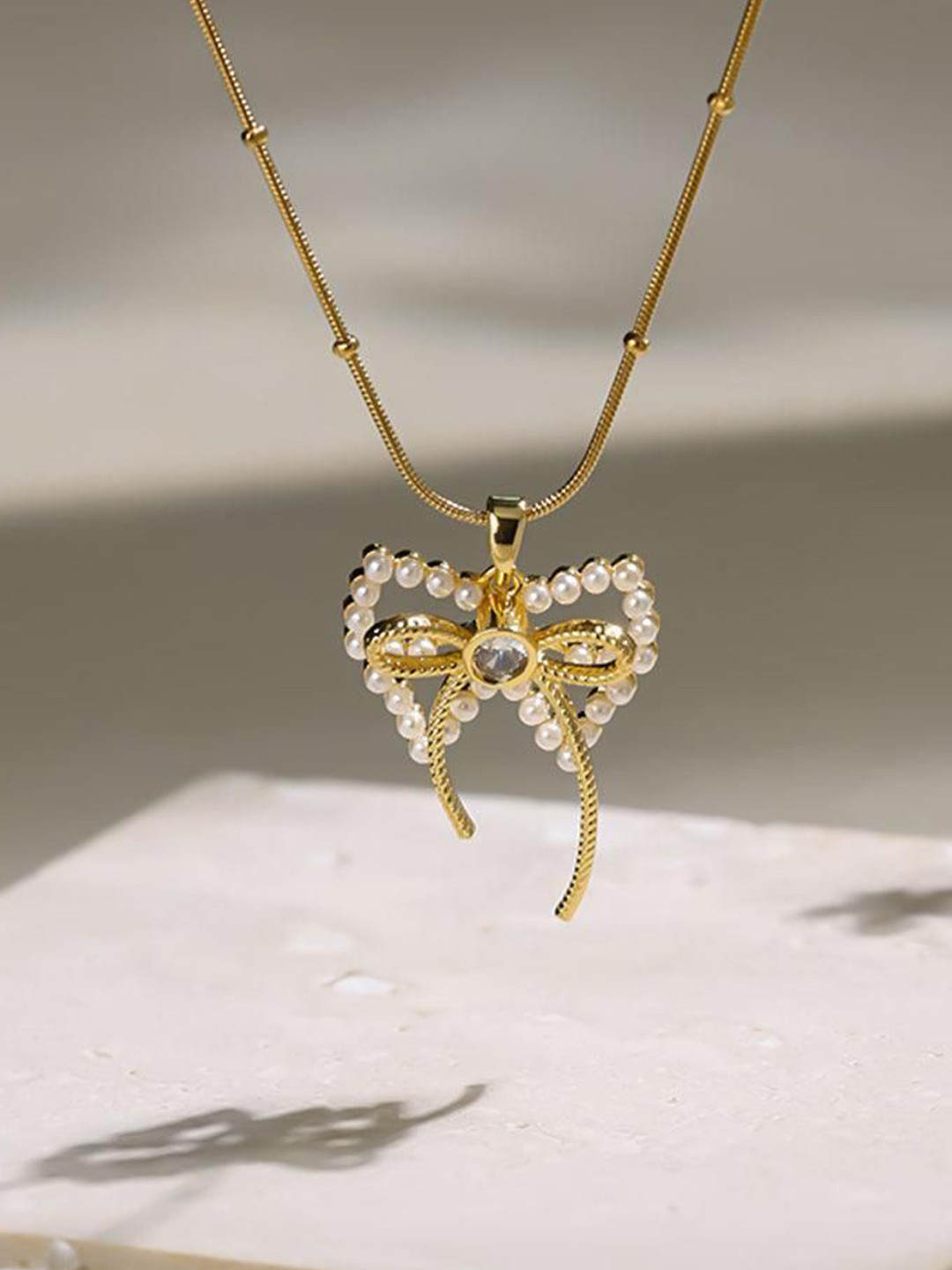 Estailo fashion Women Gold-Plated Stones-Studded & Beaded Elegance Bow Pendant With Chain