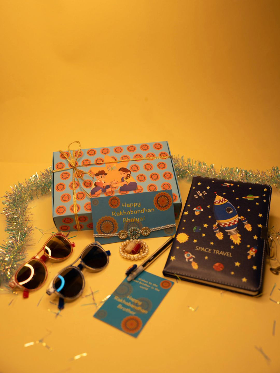 ToniQ Set of 5 Rakhi Notebook & Pen Sunglasses Greeting Card & Roli Chawal