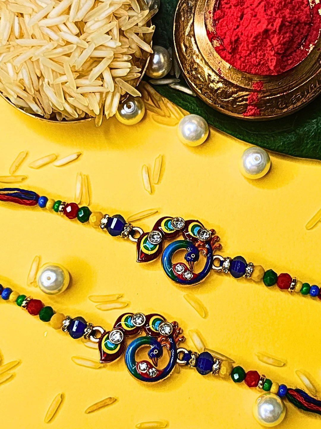 ORANGENYSHA Set Of 2 AD Stones Studded & Beaded Cotton Thread Rakhis With Rholi Chawal