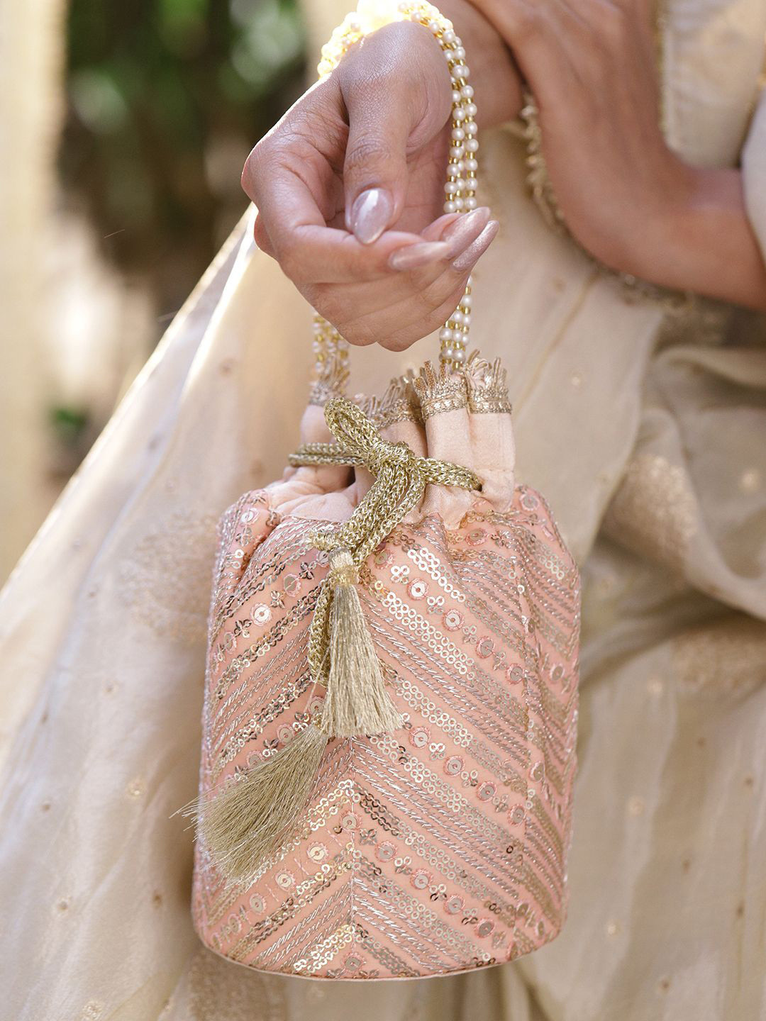 Rubans Peach Pink Sequin Embellished Potli Bag with Pearl Handle & Golden Tassel Detailing