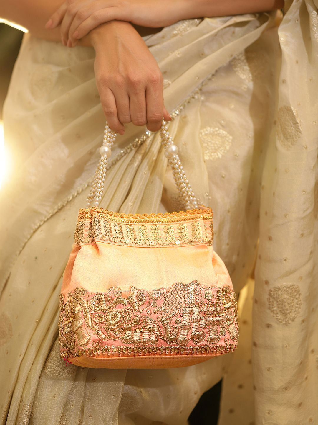 Rubans Peach Pink Silk Potli Bag with Pearl Handle & Gold Embroidered Elephant Motif