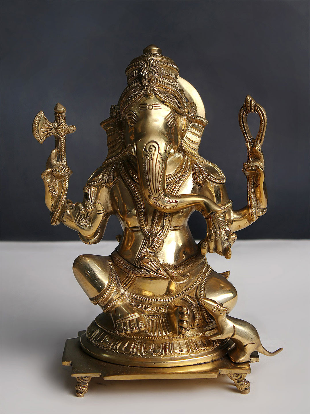 Exotic India Gold Toned Religious Lord Ganesha Seated On Pedestal Idol Showpiece