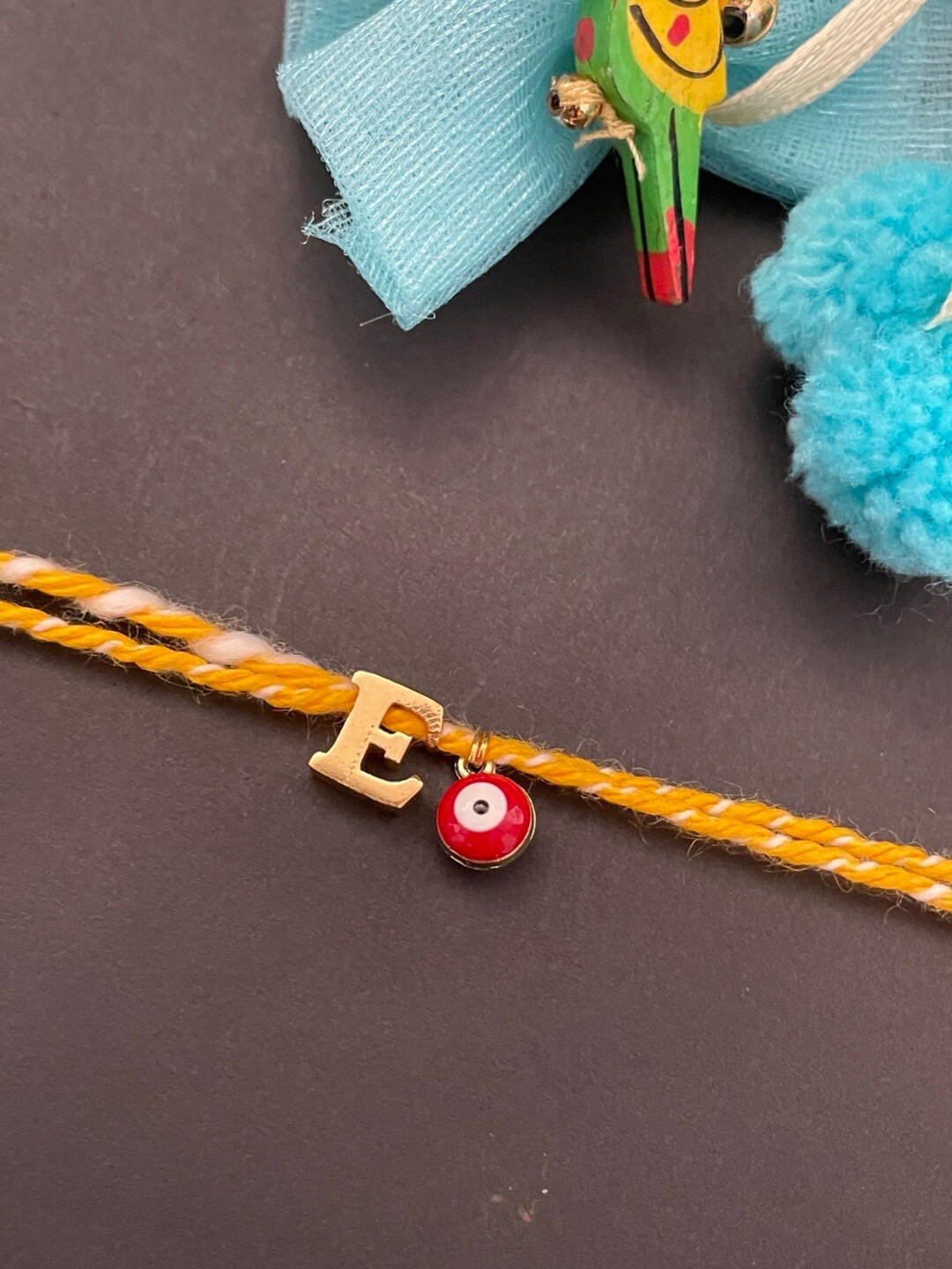 Digital Dress Room Gold-Plated E Alphabet & Evil Eye Charm Rakhi