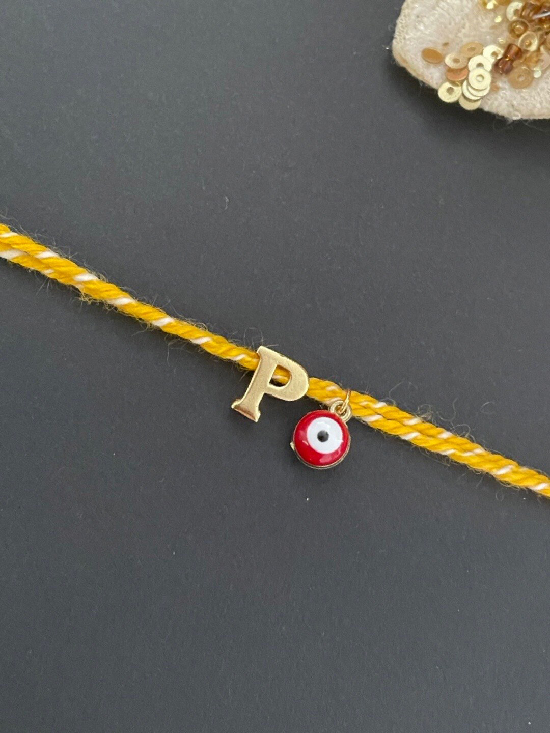 Digital Dress Room Gold-Plated P Alphabet & Evil Eye Charm Rakhi