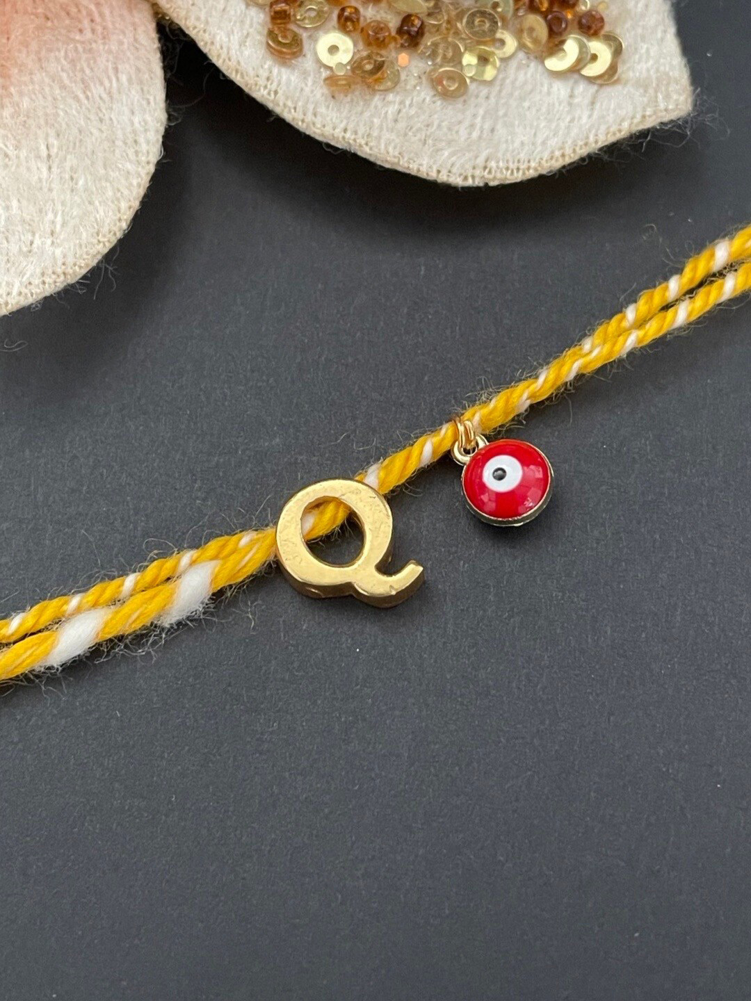 Digital Dress Room Gold-Plated Q Alphabet & Evil Eye Charm Rakhi