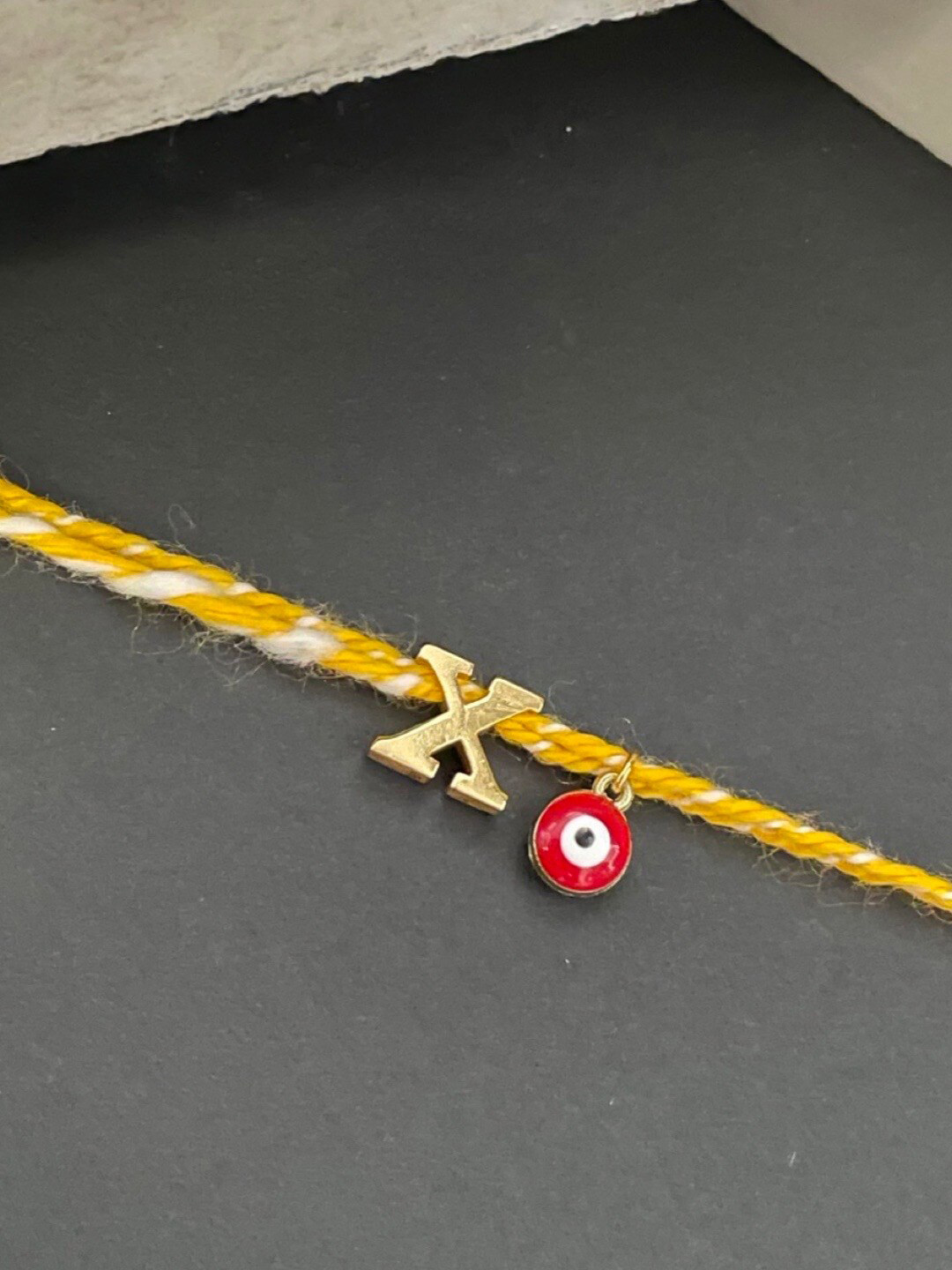 Digital Dress Room Gold-Plated X Alphabet & Evil Eye Charm Rakhi