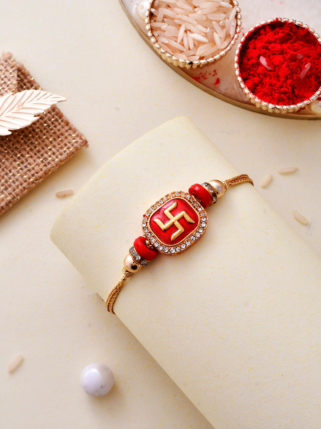 Aapno Rajasthan Gold-Plated Swastik Embossed Gemstone based Traditional Rakhi