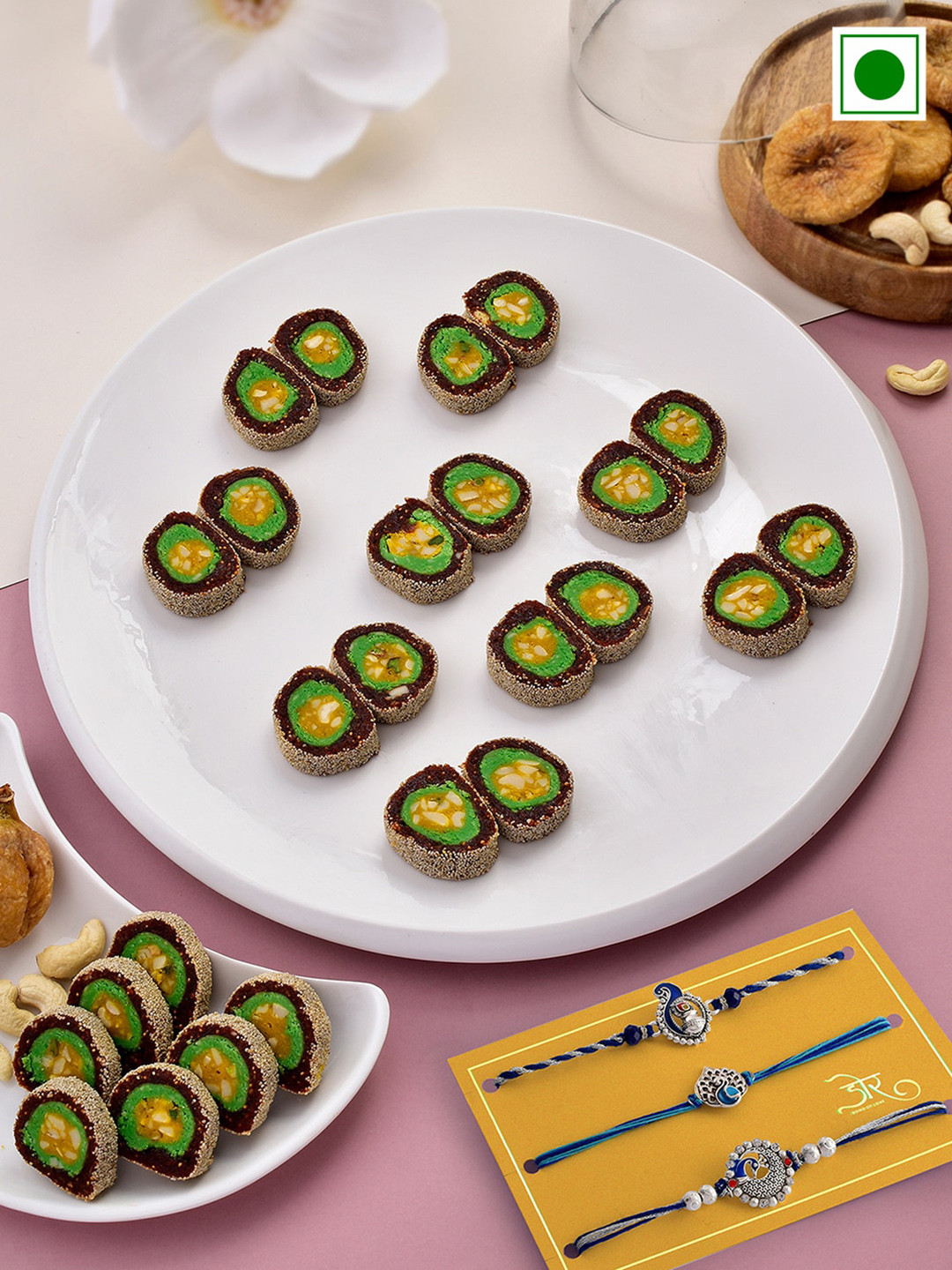 RawFruit Set Of 3 Peacock Charm Rakhis With Roli Chawal & Anjeer Chakkar Sweets-200 gms