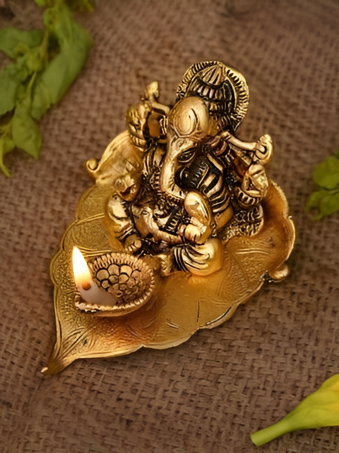 Navyaksh Ganesh Ji Sitting on Leaf with Diya Gold Metal Metallic Prayer Room Small Showpiece - 4.3 Inches