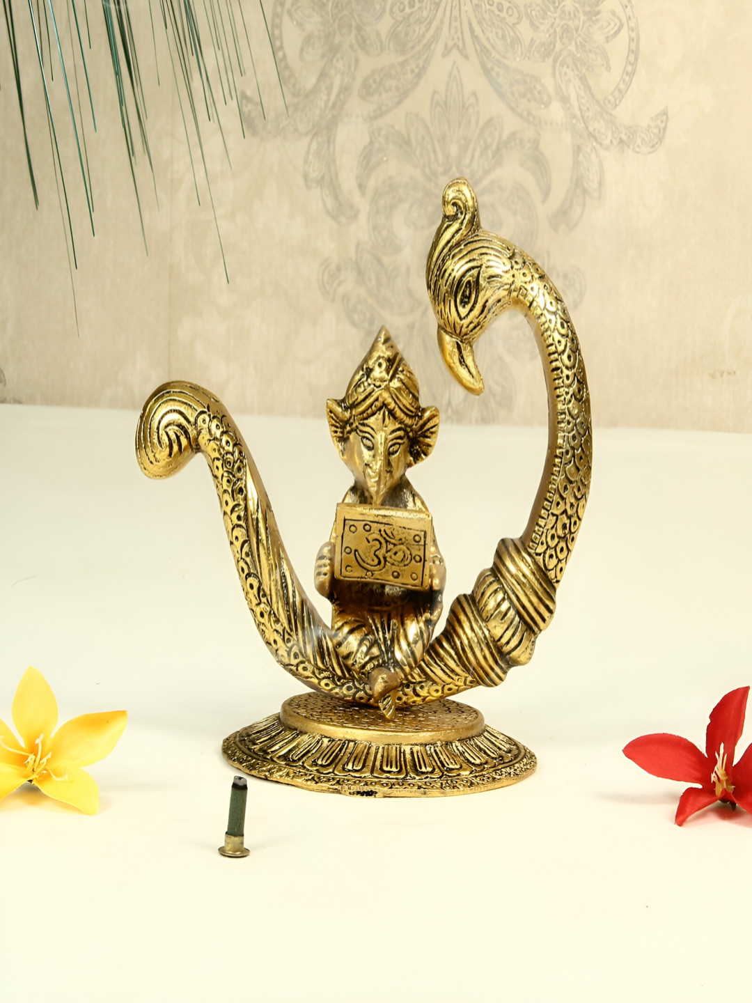 HANDICRAFTS PARADISE Lord Ganesha Reading Ramayana Seated On Peacock Gold Metal Metallic Prayer Room Medium Showpiece - 4.7 Inches
