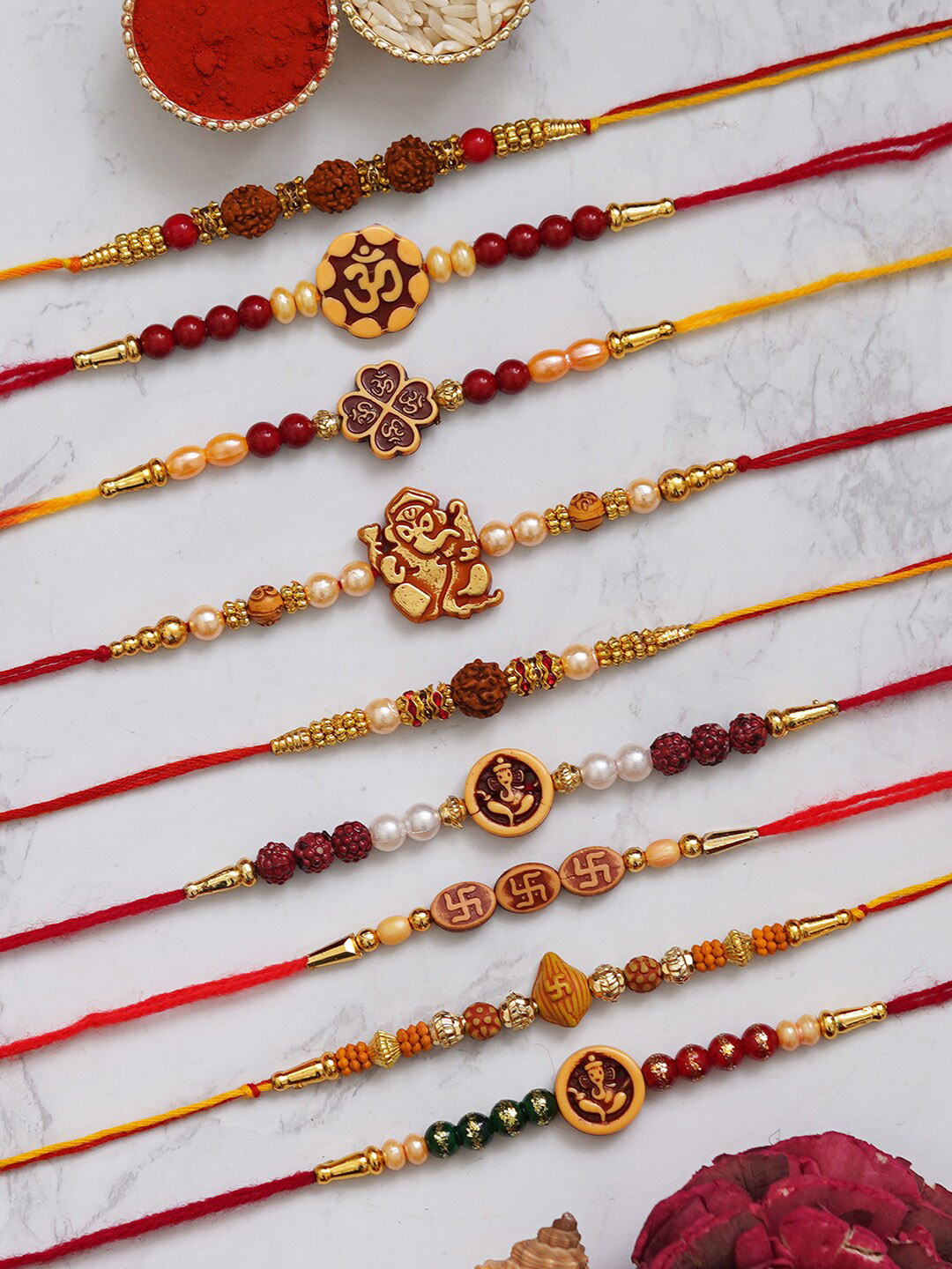 eCraftIndia Set of 9 Om Ganesha, Swastik, Rudraksha, Pearl Beaded Rakhis With Roli Chawal