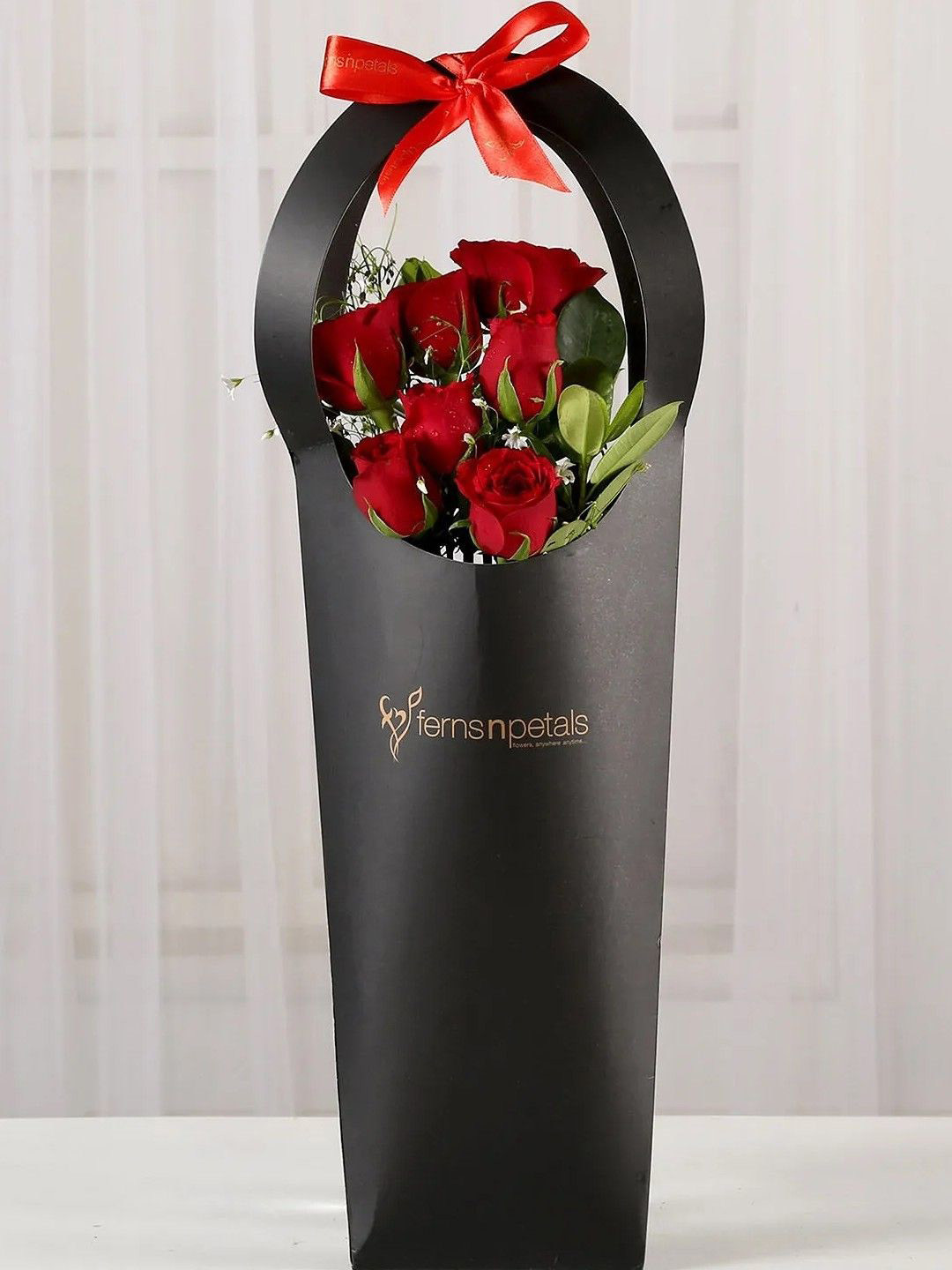 fnp Ravishing Red 7-Pcs Rose In Black Sleeves