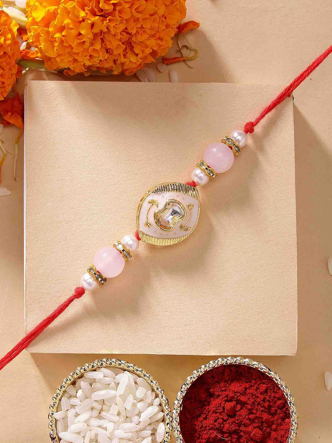 KARATCART Peach Meena Oval Shape Kundan Rakhi with Roli & Chawal