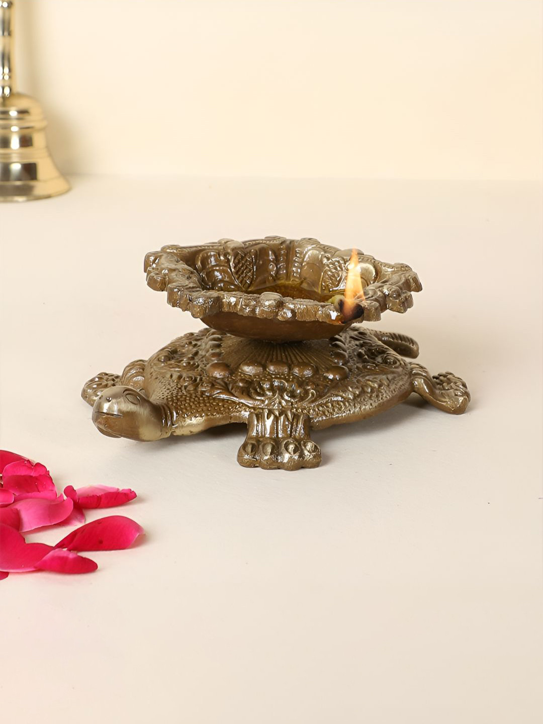 Two Moustaches Brown Swastika Engraved Brass Diya Over Tortoise