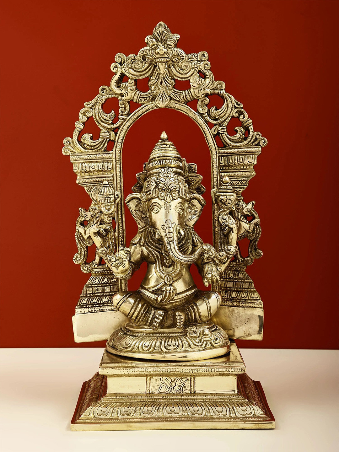 Exotic India Sitting Lord Ganesha with Kirtimukha Prabhavali Gold Brass Metallic Prayer Room Medium Showpiece - 12.8 Inches